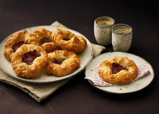 Schulstad Raspberry Crown Danish pastries with raspberry purée nestled between layers of golden, flaky pastry for a sweet and tart bite. Finished with icing.