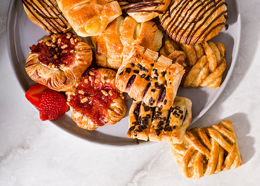A signature selection of Schulstad Mini Danish Pastries featuring standout flavors like Strawberry Shortcake, Salted Caramel, Lemon Cheesecake, Toasted Coconut Swirl, and Cherry Chocolate
