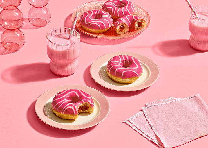 Schulstad Pink Bliss Strawberry Filled Ring Donuts with sweet strawberry flavored filling, topped with pink frosting and a white drizzle